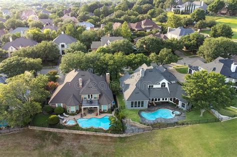 Aerial View Of Mansions With Swimming Pools Surrounded By Green Grass