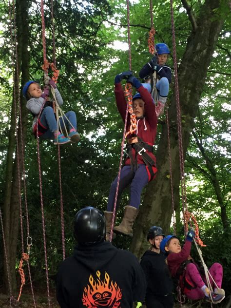 Children working on the harness technique for tree climbing with ropes