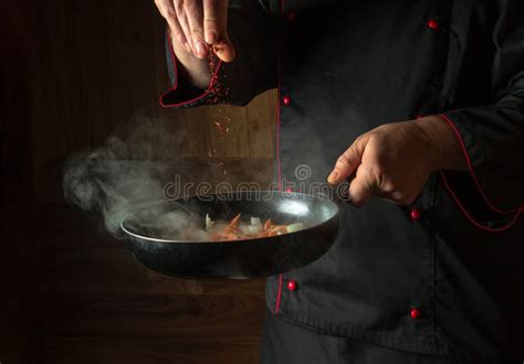The Chef Adds Dry Fragrant Spices To A Hot Pan Roasting Onions With Carrots Before Cooking
