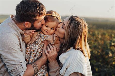 Fondo Feliz Familia Caucásica Al Aire Libre Besando A Su Hija Al