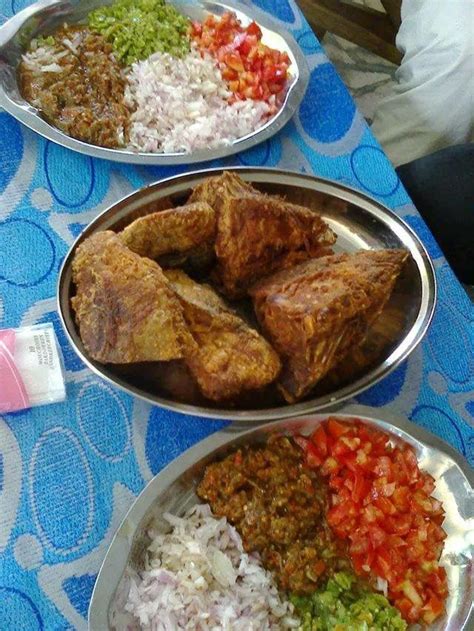 Three Metal Pans Filled With Food On Top Of A Blue And White Table Cloth