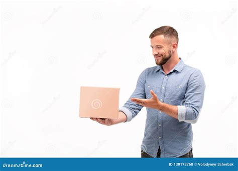 Casual Young Man Holding A Box Isolated On A White Background Stock