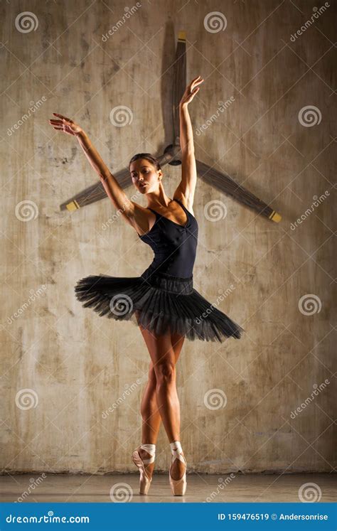 Young Beautiful Ballerina In Black Ballet Tutu Posing In Dark Studio