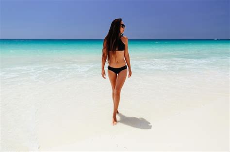 Premium Photo Woman In Bikini Walking At Beach Against Sky