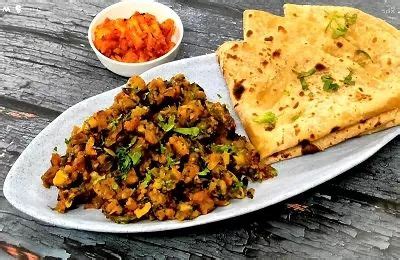 A White Plate Topped With Food Next To A Bowl Of Chili And Pita Bread