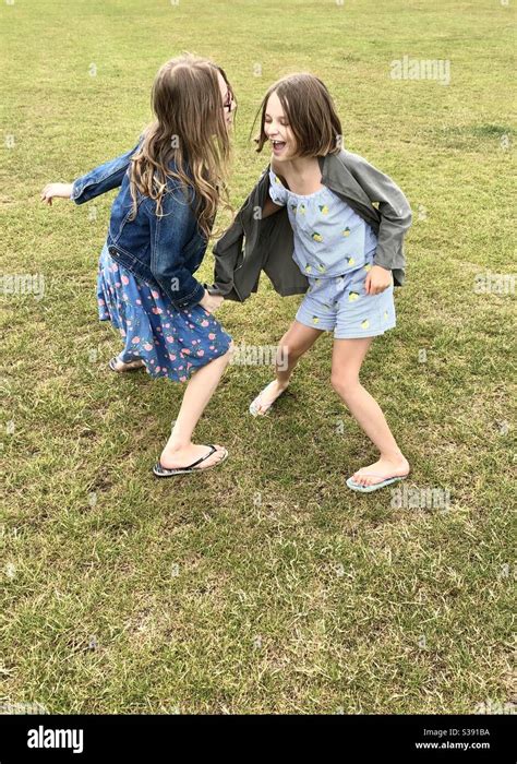 Two Sisters Play Fighting On A Field Stock Photo Alamy