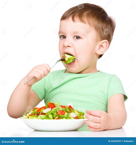 El Niño Pequeño Lindo Está Comiendo La Ensalada Vegetal Imagen De