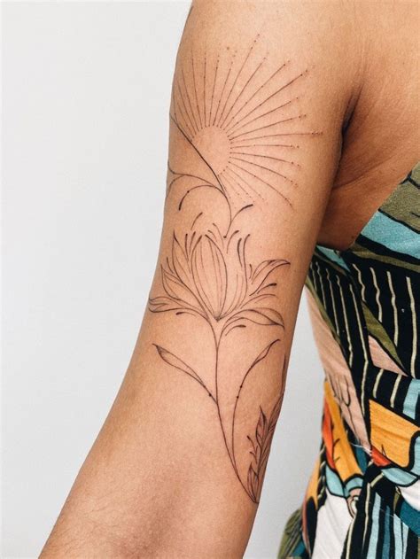 A Woman S Arm With A Tattoo On It That Has A Flower In The Center