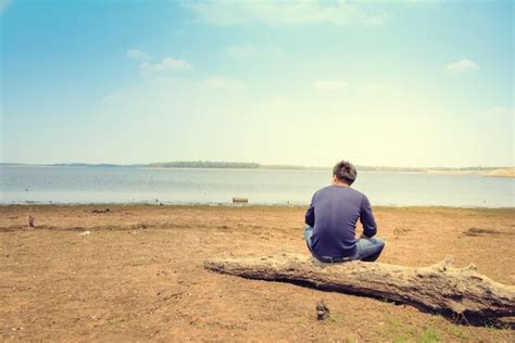 Premium Photo Rear View Of Man Sitting On Beach