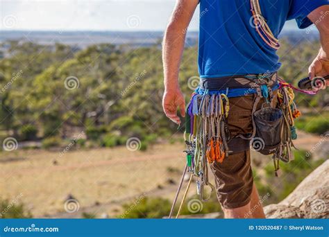 A Rock Climber Checks His Gear And Radio Before Climbing Stock Image