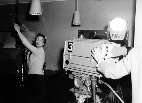 An Old Black And White Photo Of Two People Working On A Projector