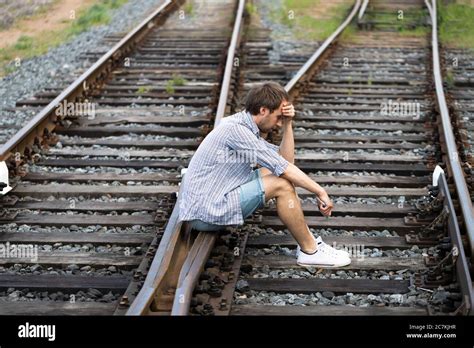 Un Hombre Deprimido Sentado En Las V As Del Ferrocarril Sosteniendo El