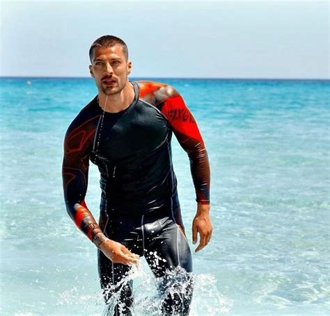 A Man Standing In The Ocean Wearing A Wet Suit