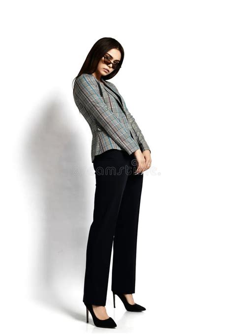 Sexy Brunette Vrouw Stelt Ons Zijwaarts In Een Stijlvol Gevild Jasje Zwarte Broek Met Hoge Hak