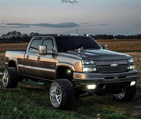 Silver Chevy Duramax Lifted Truck In Field At Dusk