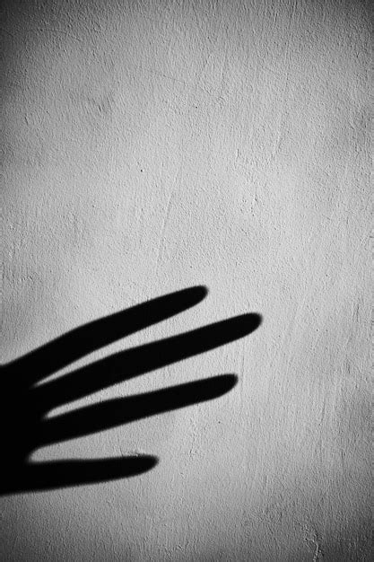 Sombra de la mano del cultivo en la pared gris Foto | Foto Premium