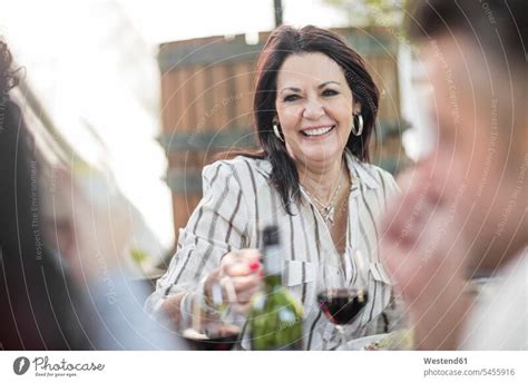 Lächelnde ältere Frau beim Familienessen im Garten ein lizenzfreies