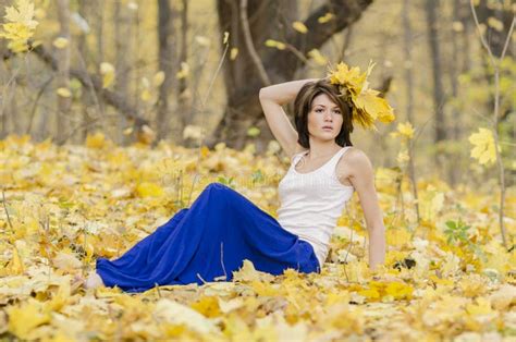 Young Girl In Autumn Forest With A Bouquet Of Mapple Leaves Stock Photo