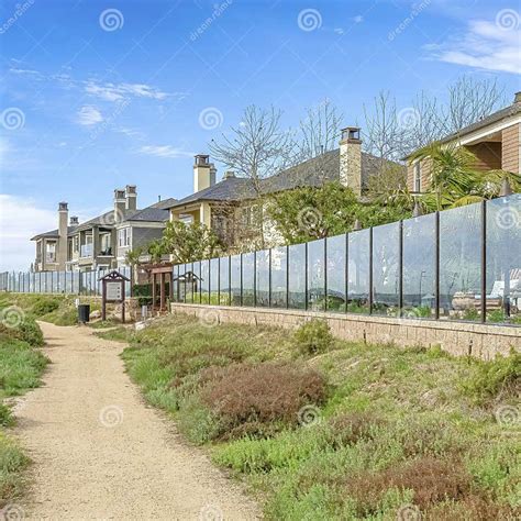 Square Pathway Along Homes With Glass Fences Under Skyscape Of Blue Sky