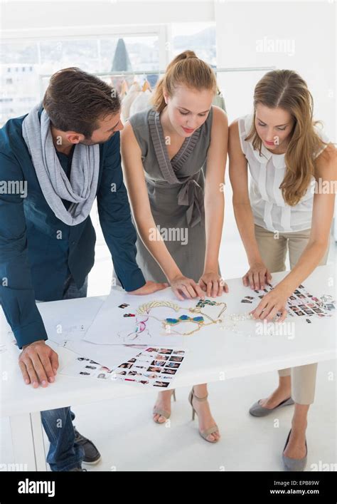 Three Fashion Designers Discussing Designs Stock Photo Alamy