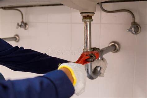 Plumber Fixing White Sink Pipe With Adjustable Wrench Stock Photo