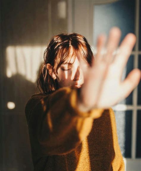 A Woman Is Holding Her Hands Up In The Air While She Looks Down At Something