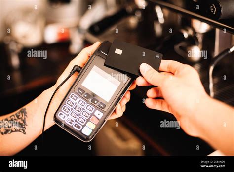 Barista Holding Credit Card Reader Terminal While Customer Making