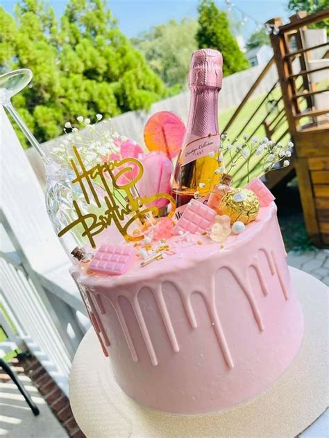 A Pink Birthday Cake Sitting On Top Of A Table