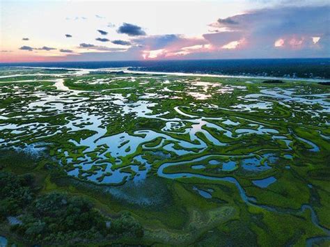 An Aerial View Of The Marshy Land At Sunset Or Dawn With Clouds In The Sky