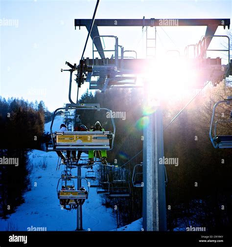 Skiers On Chair Lift With Sun Glare Stock Photo Alamy