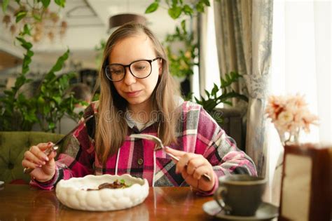 Female Sitting At Table With Plate Of Food A Woman Is Sitting At A