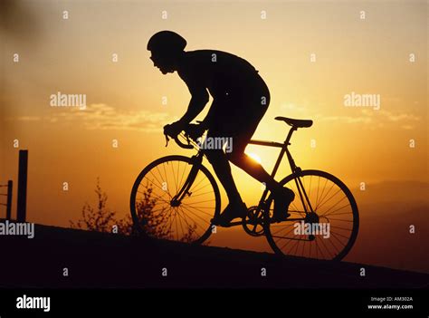 A silhouette of a road biker at sunset Stock Photo - Alamy