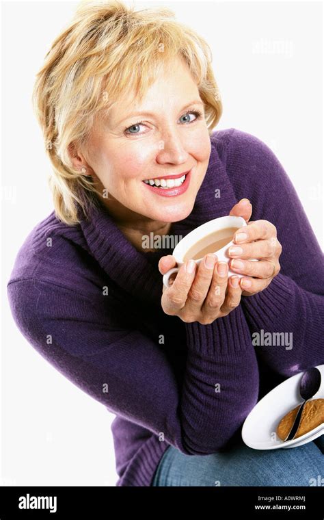 Mature Woman Holding And Drinking A Cup Of Hot Sweet Warming Tea Stock Photo Alamy