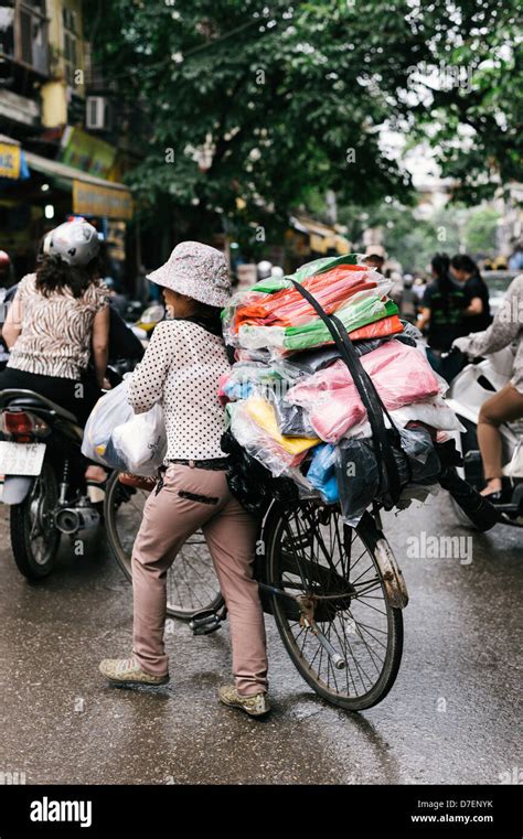 Hanoi Vietnam A Female Street Vendor Wheeling Her Loaded Bicycle In The Historic Old Quarter