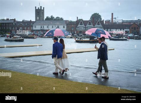 A Group Walk Along The Towpath In The Rain Under Colourful Pink And