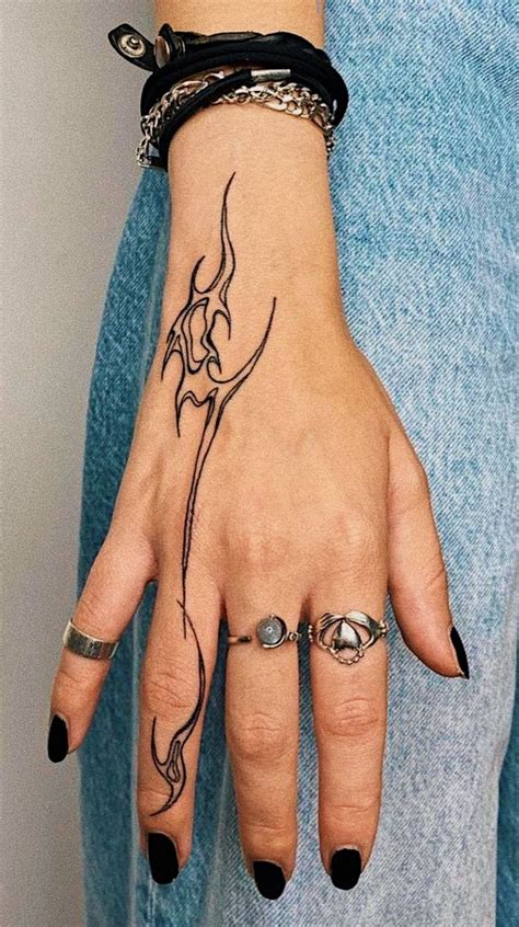 A Woman S Hand With Tattoos And Rings On Her Left Wrist Wearing A