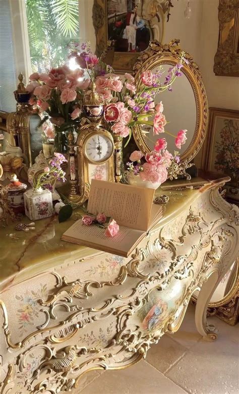 An Ornately Decorated Desk With Pink Flowers On It And A Mirror In The