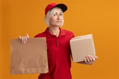 Femme De Livraison Blonde D âge Moyen Confiante En Uniforme Rouge Et