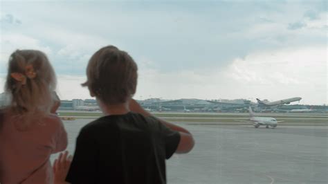 Kids waiting at the airport and watching planes from the terminal ...