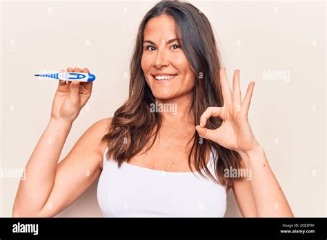 Beautiful Brunette Woman Controlling Temperature Holding Thermometer
