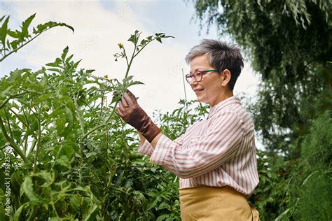 Beautiful Joyous Mature Woman With Glasses Taking Active Care Of Her