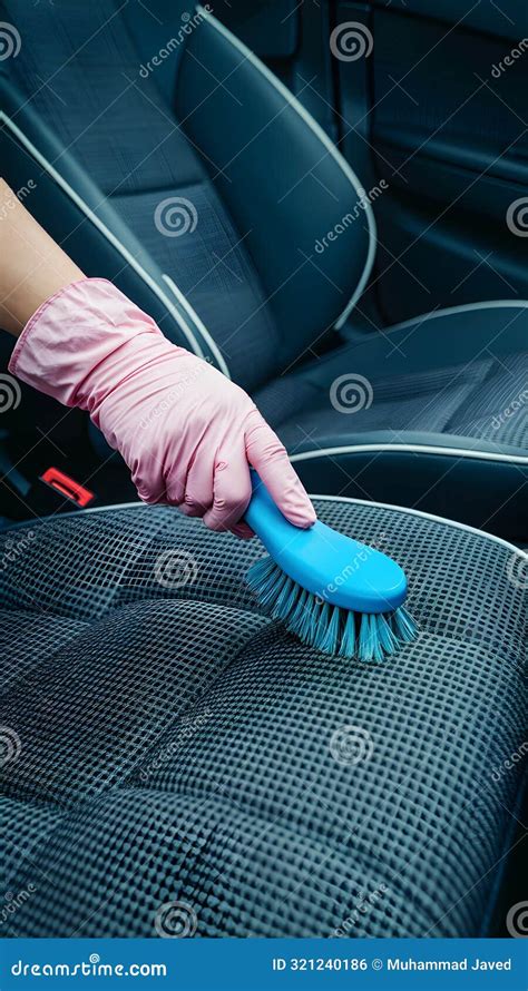 Pink Gloved Hand Brushes Blue Upholstery With Checkered Pattern In Car