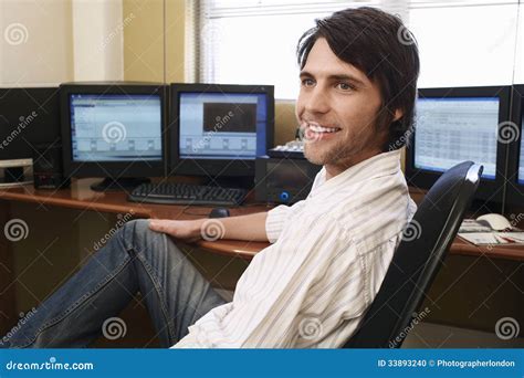 Man Sitting At Desk In Front Of Computers Stock Photo Image 33893240