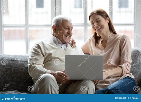 Smiling Mature Dad And Grownup Daughter Using Laptop Stock Photo