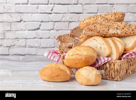 Various Types Of Bread And Pastries In A Basket On A Wooden Table In