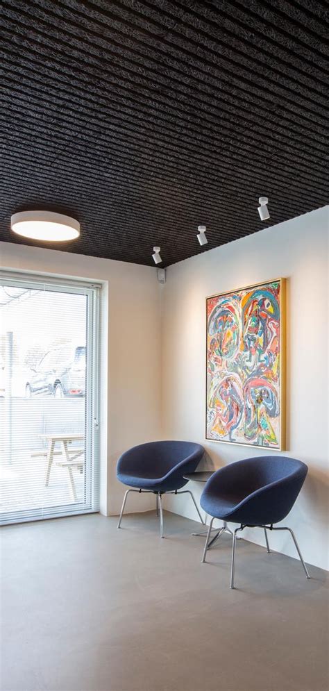 Two Blue Chairs Sitting In Front Of A Painting On The Wall Next To A Window