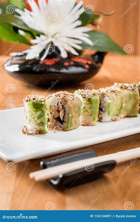 Japanischer Sushirollengrüner Drache Mit Aal Und Avocado Mit Ingwer Auf