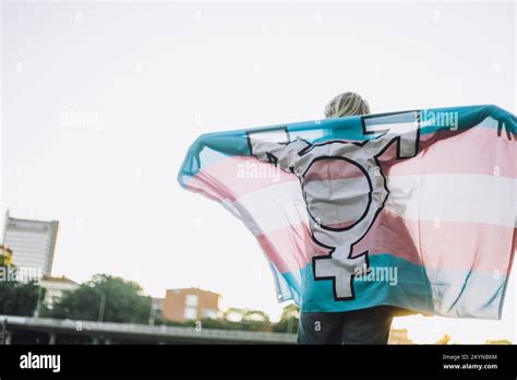 Rear View Of Non Binary Person Standing With Lgbtqia Flag Against Clear