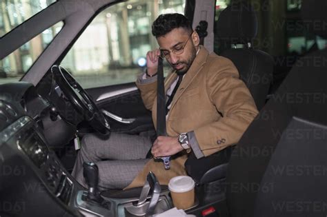 Businessman Buckling Seat Belt In Car Stock Photo