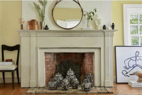 A Living Room Filled With Furniture And A Fire Place Covered In Vases